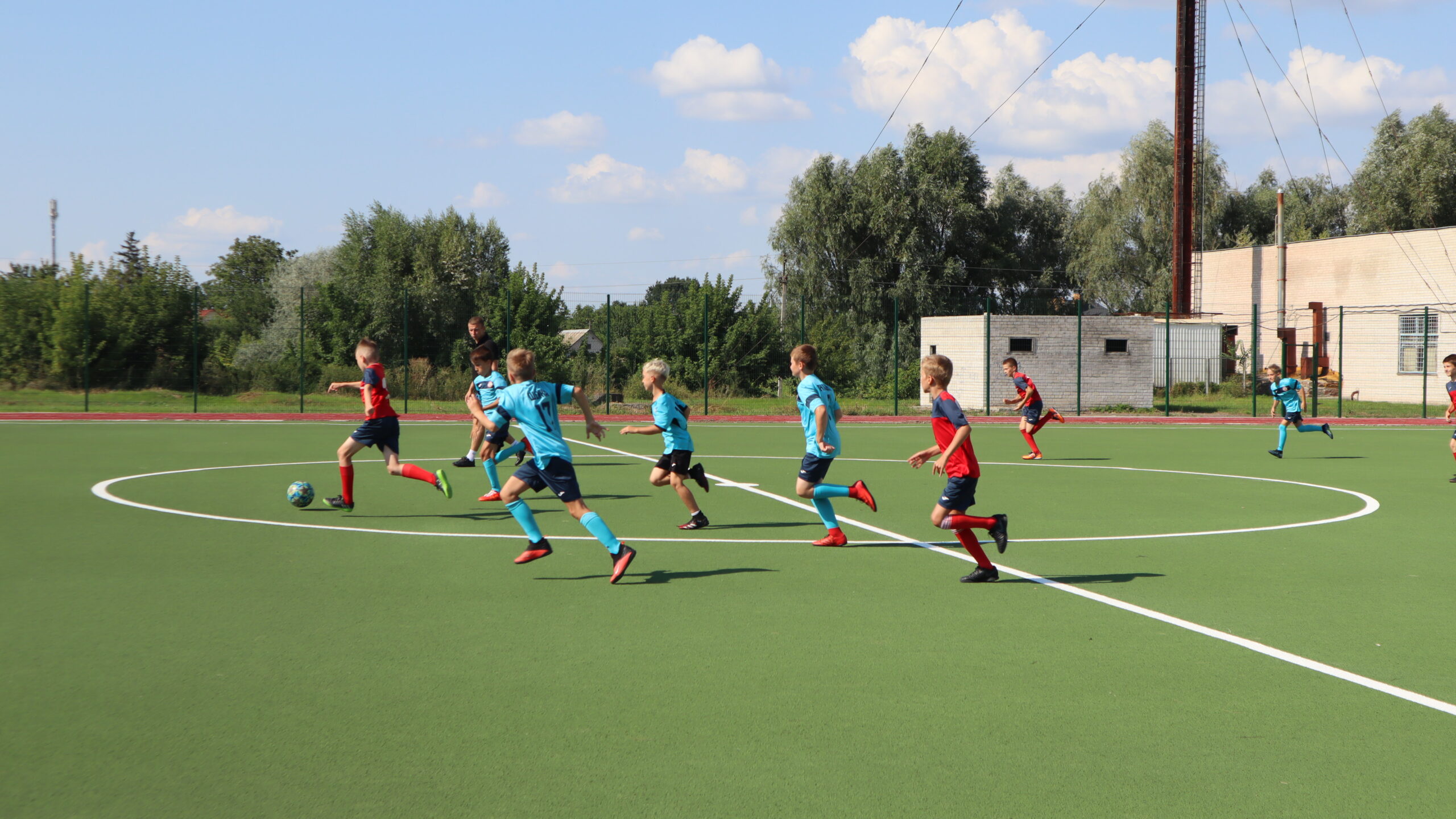 діти бігають по футбольному полю